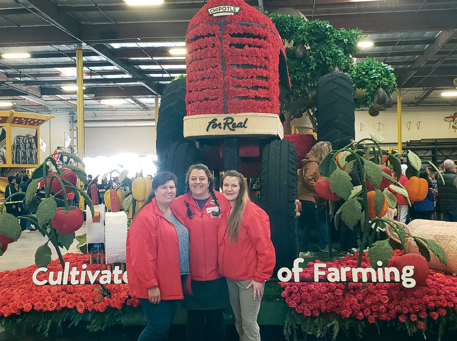 Sharrai Morgan, owner of Holly’s Fine Flowers in Port Townsend, is flanked by members of her “flower family” in front of their completed float for the 2010 Rose Parade.